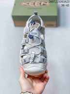 Front view showing the gray webbing, open panels, and blue lace toggle.