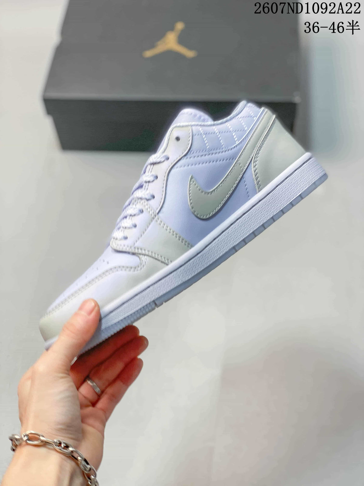 Side profile showing the light lavender upper, white Swoosh-style side branding, and textured sole.