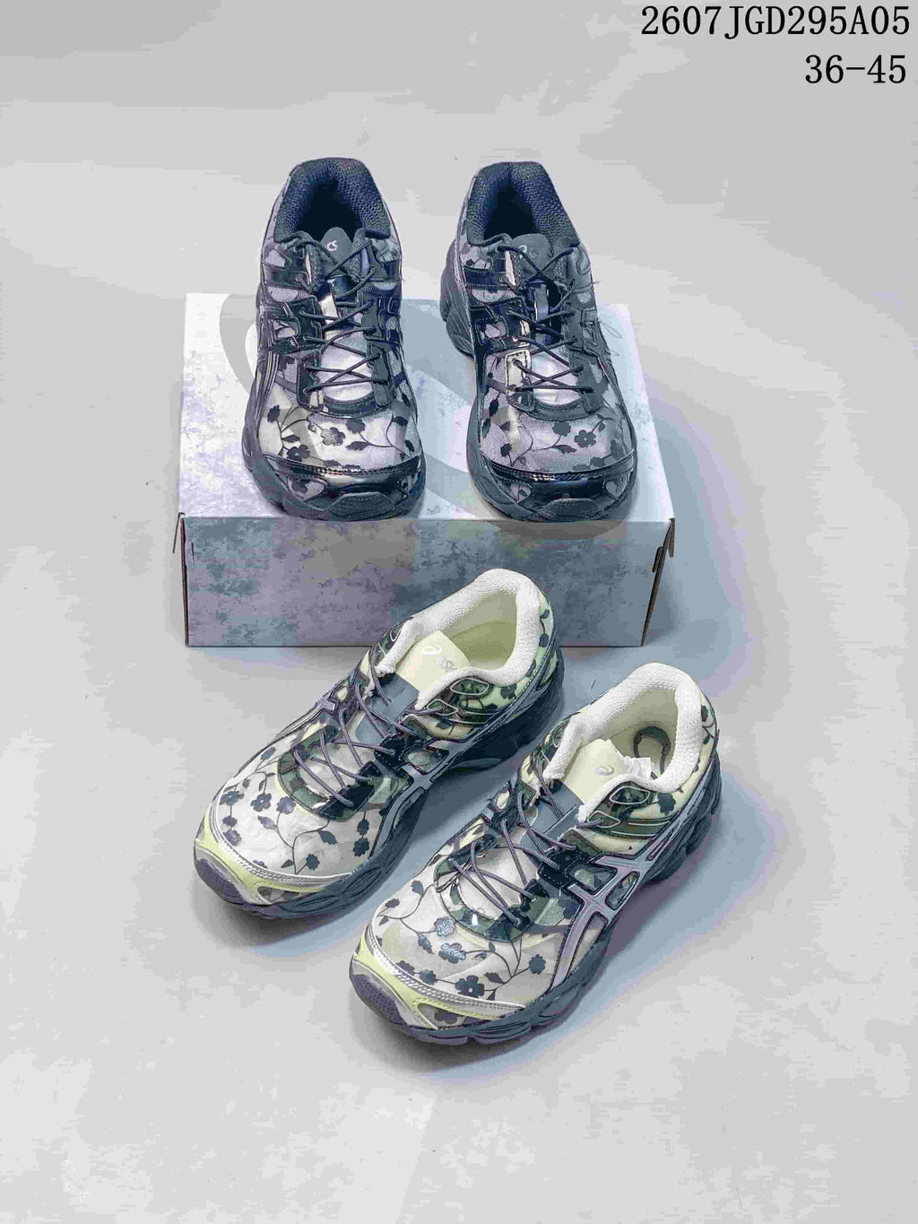 Dark gray and light green floral ASICS sneakers arranged around a shoe box.