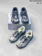 Dark gray and light green floral ASICS sneakers arranged around a shoe box.