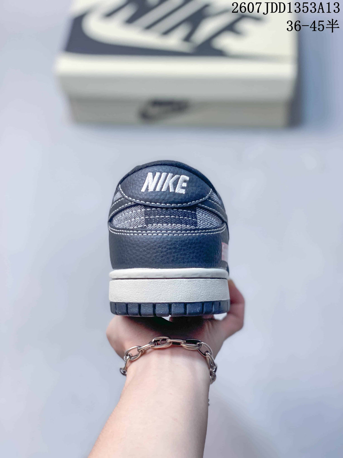 Rear view showing the padded heel, contrast stitching, white midsole, and navy outsole.
