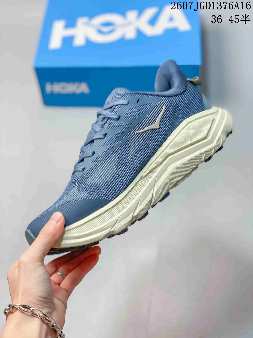 Side profile of the blue lace-up shoe showing the textured upper, cream midsole and orange accent line.