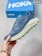 Side profile of the blue lace-up shoe showing the textured upper, cream midsole and orange accent line.