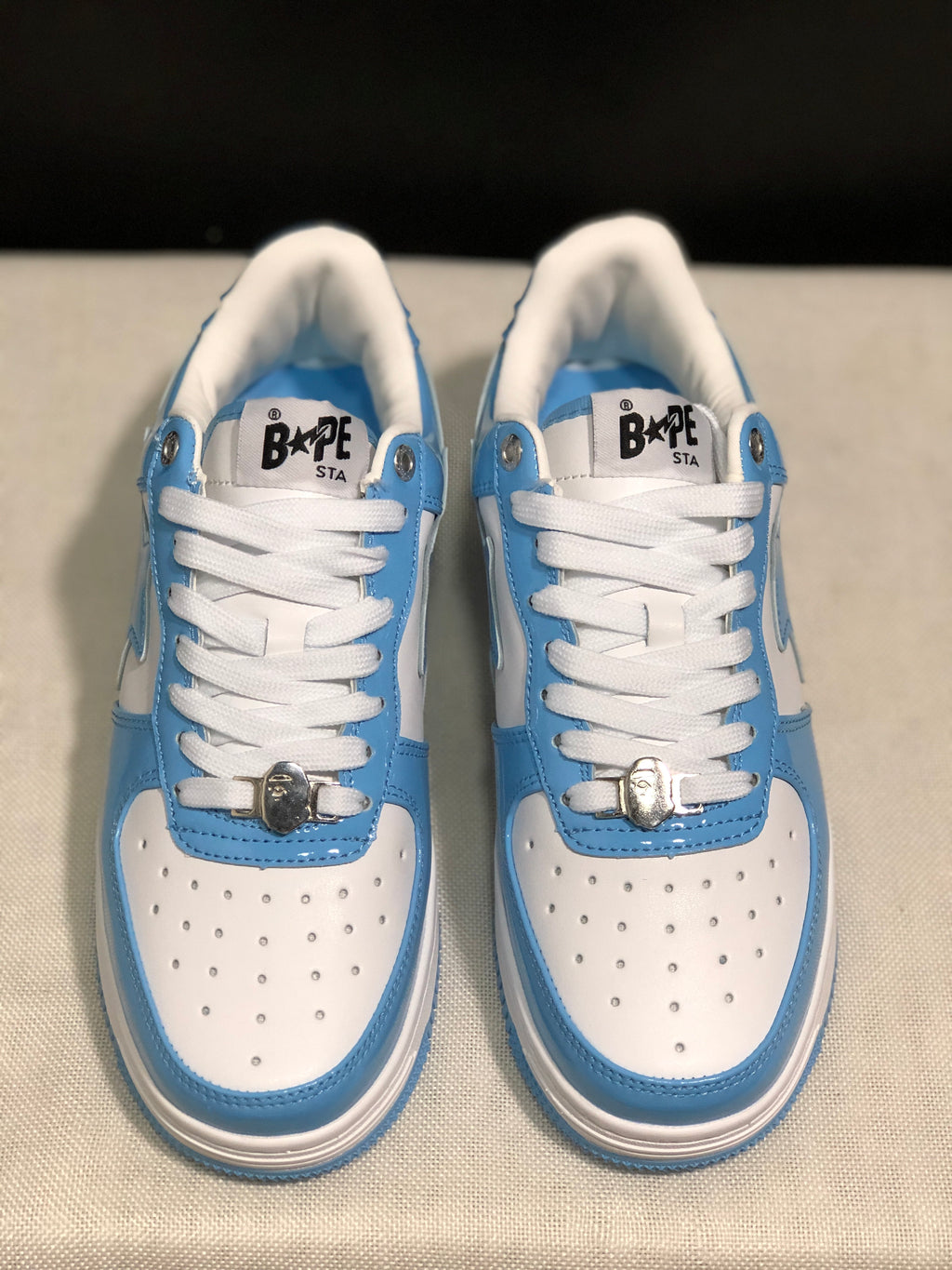 Close top view of the pair showing the blue and white panels, padded collars, white laces, and BAPE STA tongue labels.