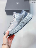 Side profile of the gray and silver KAILAS trail shoe showing the layered upper, structured panels, and lugged outsole.