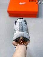 Rear view of a white Nike Pegasus 42 shoe showing the heel branding, padded collar, and black outsole sections.