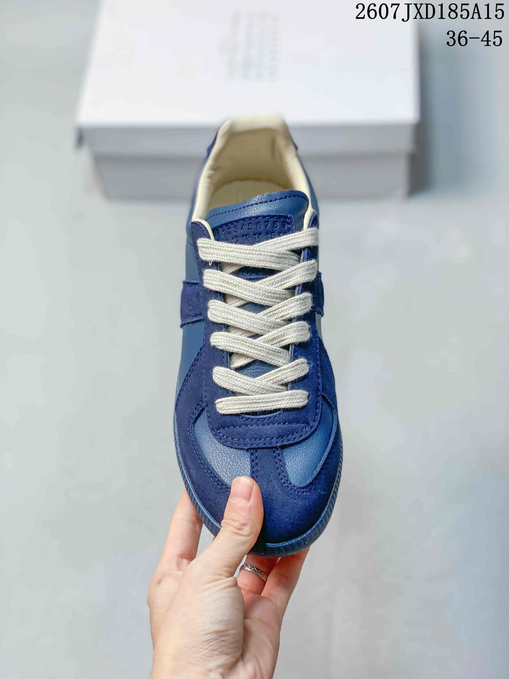 Top view of the blue sneaker showing white laces, layered toe panels, and cream-colored interior lining.