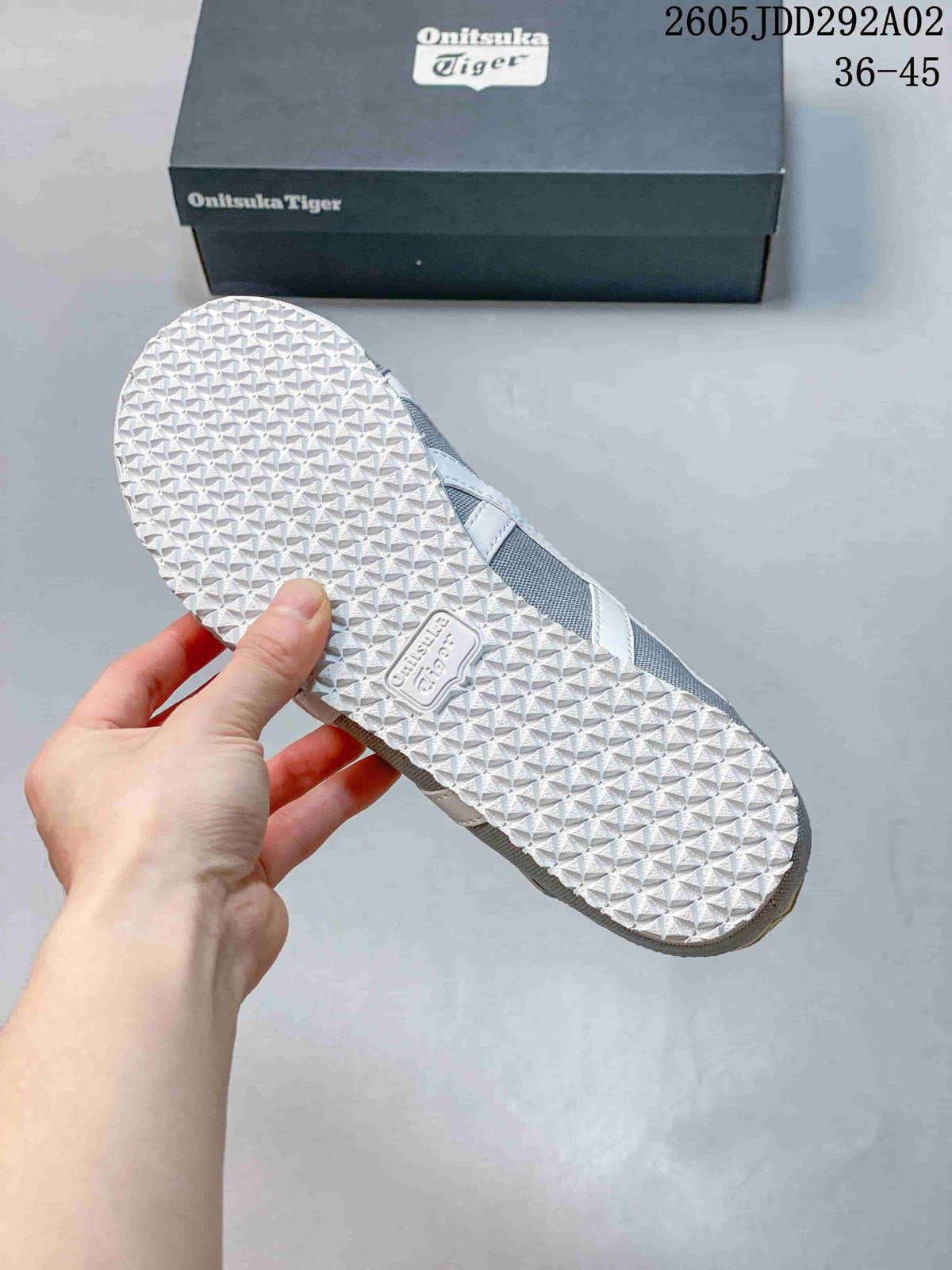 Underside view showing the textured white rubber outsole and Onitsuka Tiger branding.