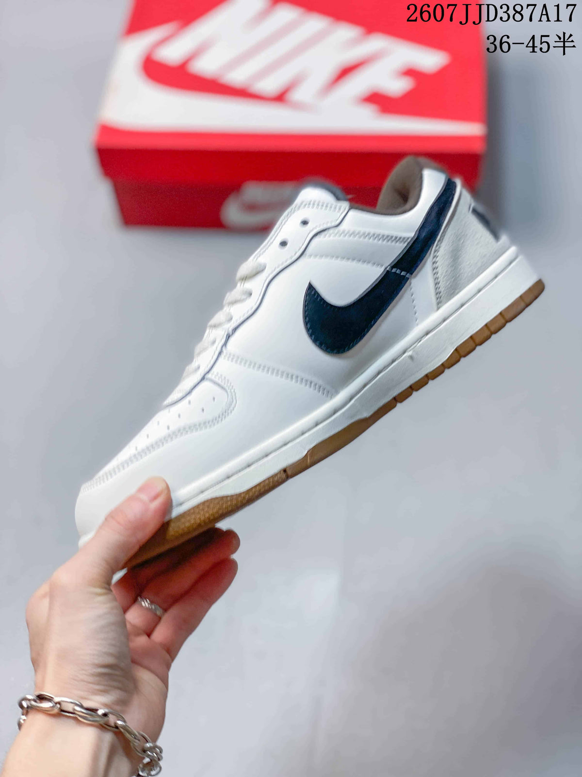 Side profile of the white low-top sneaker with navy side detailing and a gum-colored outsole.