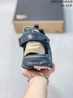 Rear view of a black sandal showing the heel strap, open heel area, textured outsole, and visible branding.