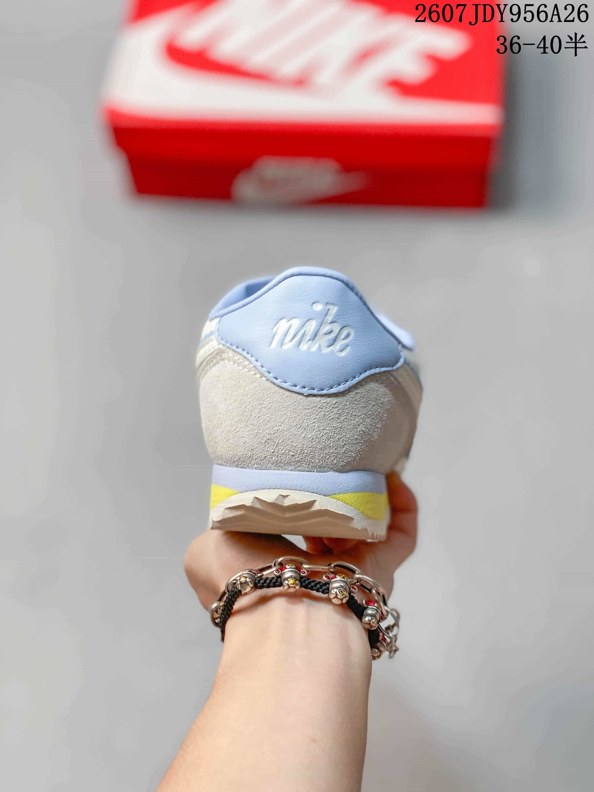 Rear view showing the light blue heel tab, textured heel panel, and yellow midsole accent.
