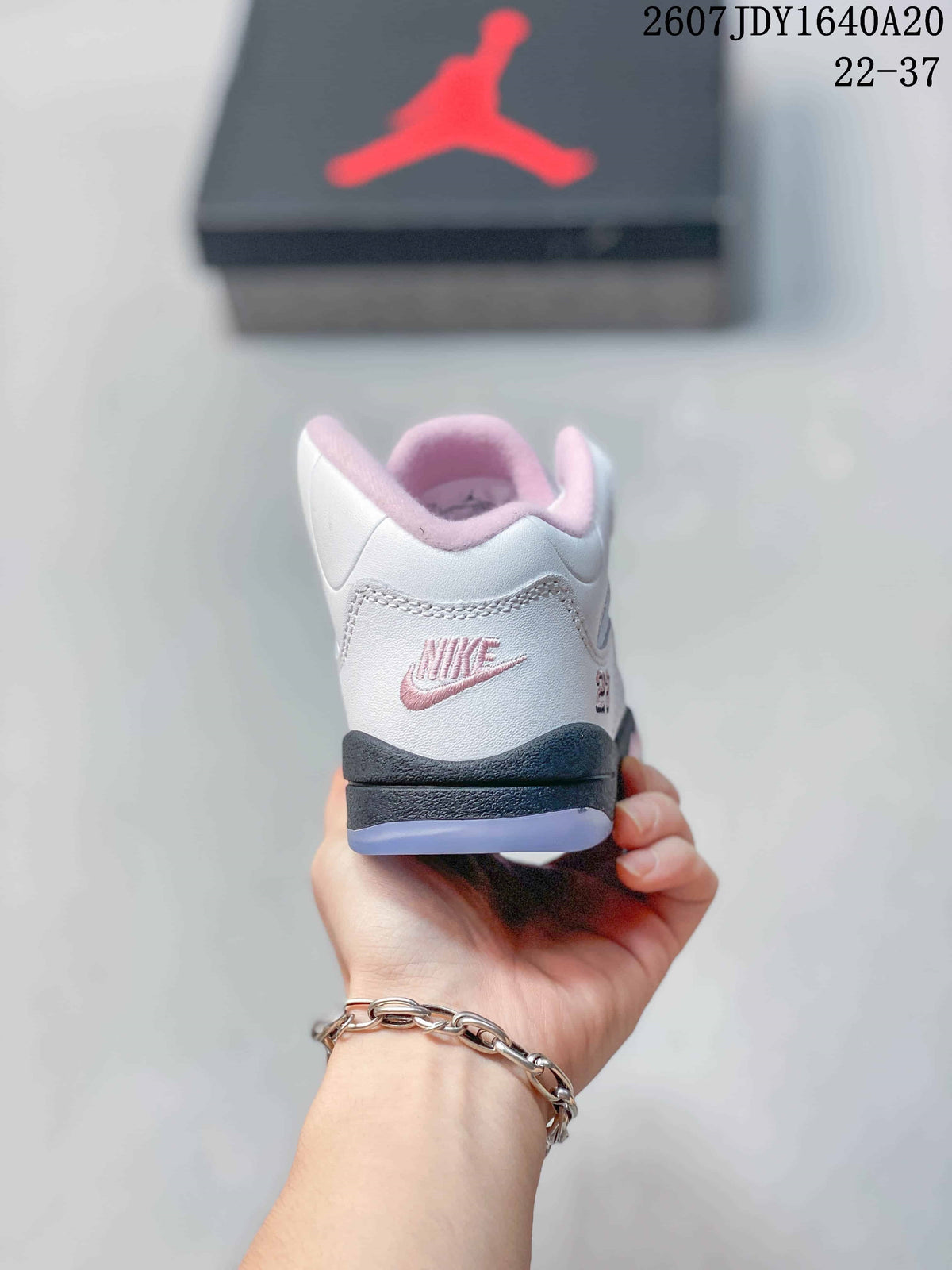 Rear view showing pink heel branding, padded collar lining, and the black outsole edge.