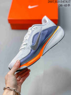 Side view of a Nike Pegasus 42 shoe showing the white and blue upper, Nike swoosh and orange midsole.