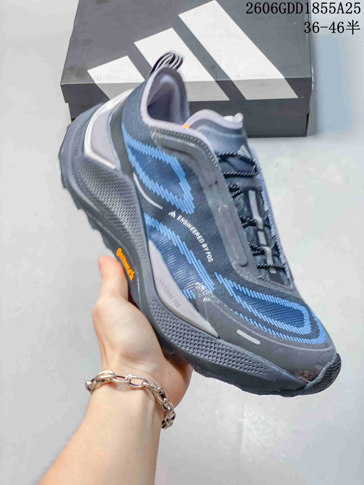 Angled side view of the gray and blue trail running shoe