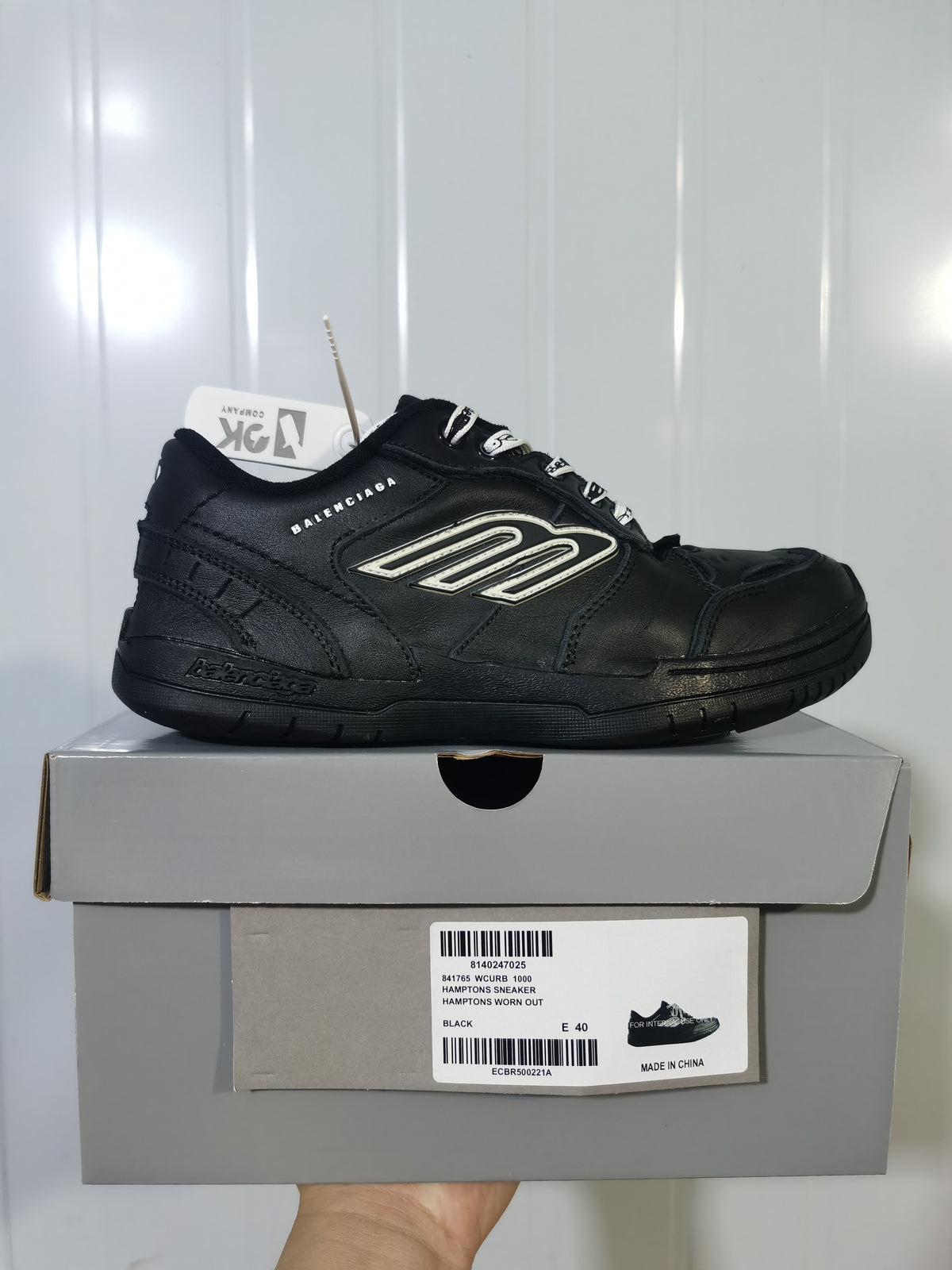 Black Balenciaga sneaker displayed on a shoe box; the visible box label reads Hamptons Sneaker, Black, E 40.