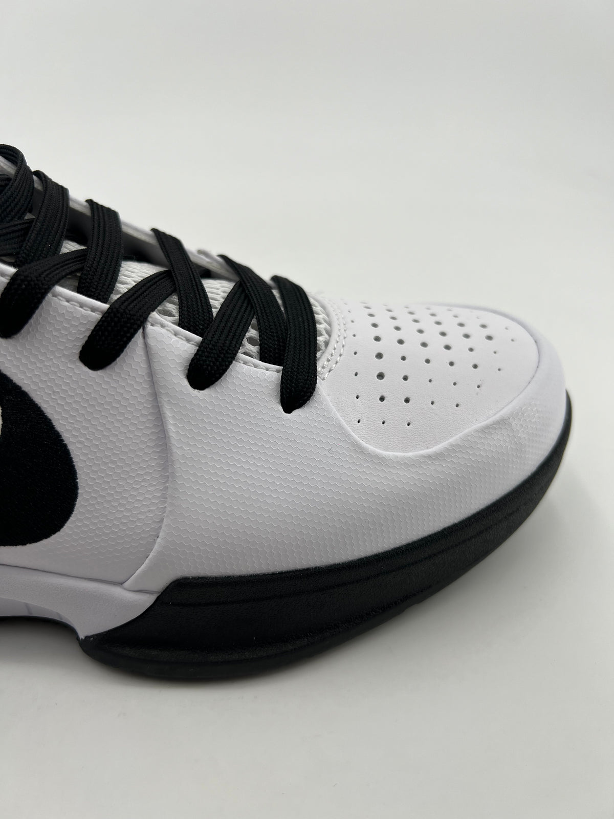 Close-up of the perforated toe, white upper, and black outsole
