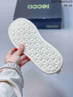 Close-up of the white textured outsole showing a repeating geometric tread pattern.