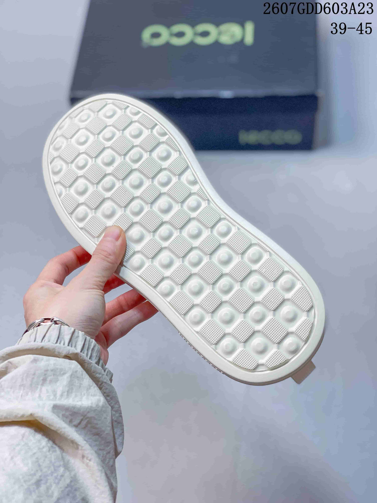 Close-up of the white textured outsole showing a repeating geometric tread pattern.
