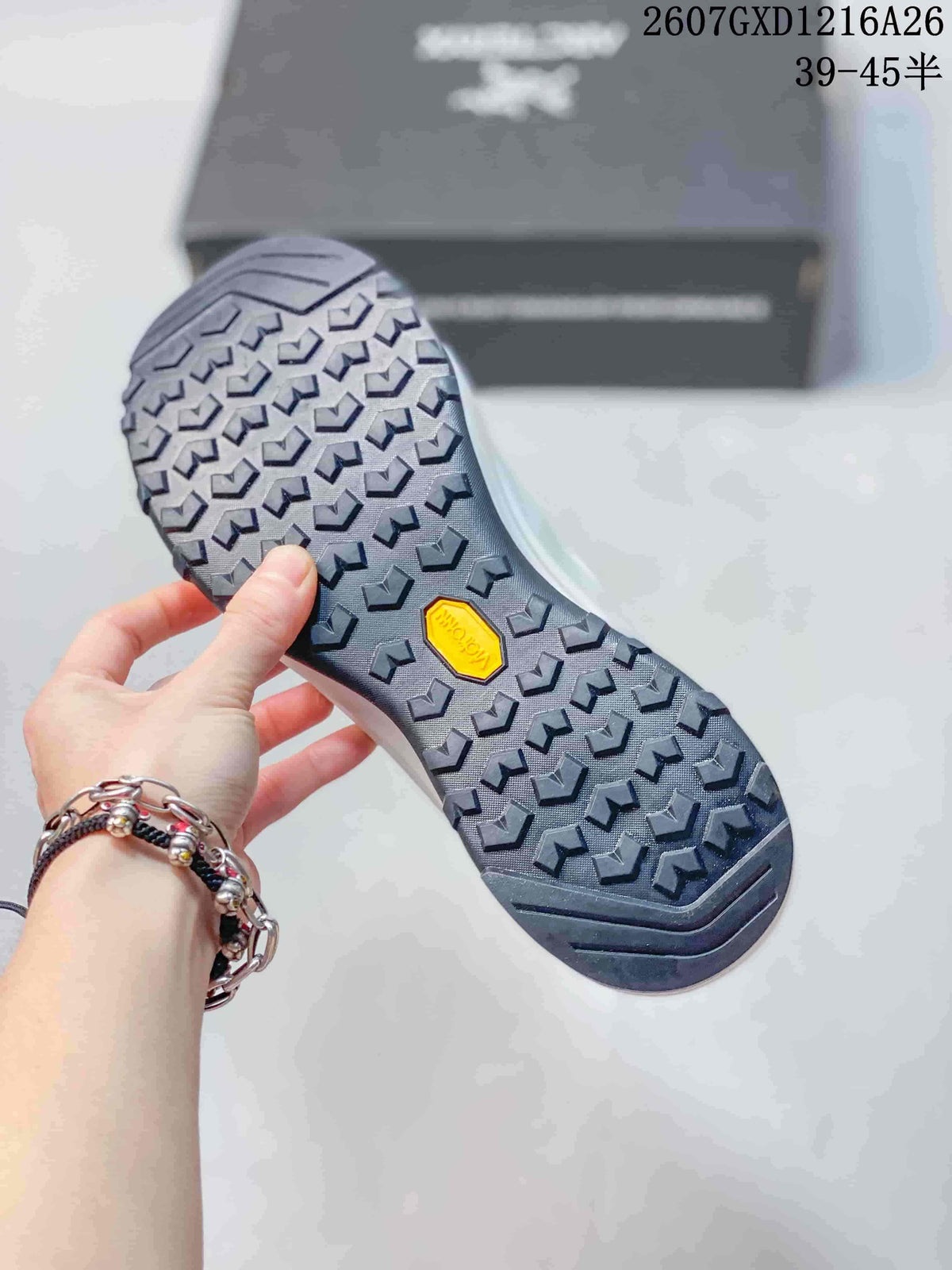 Close view of the dark patterned outsole with a yellow center insert and repeated lug tread.