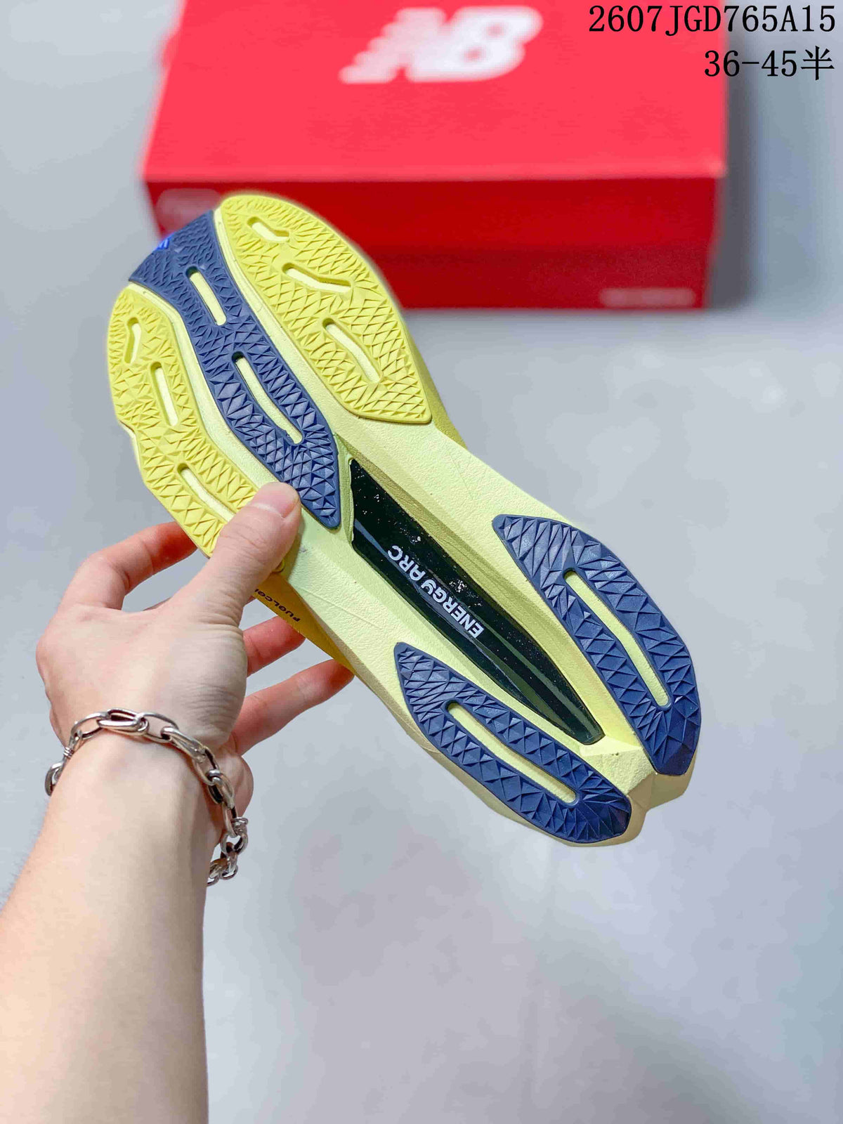 Close view of the shoe outsole showing pale yellow and dark blue traction sections with a central ENERGY ARC marking; overlay text shows size range 36–45.