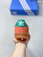 Rear view showing the coral heel, green heel tab, adidas branding and gum-colored sole.