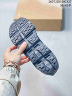 Close view of the dark gray sneaker outsole showing patterned tread and multiple raised sections.