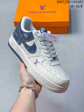 White low-top sneaker with navy overlays, blue swoosh, and contrast stitching