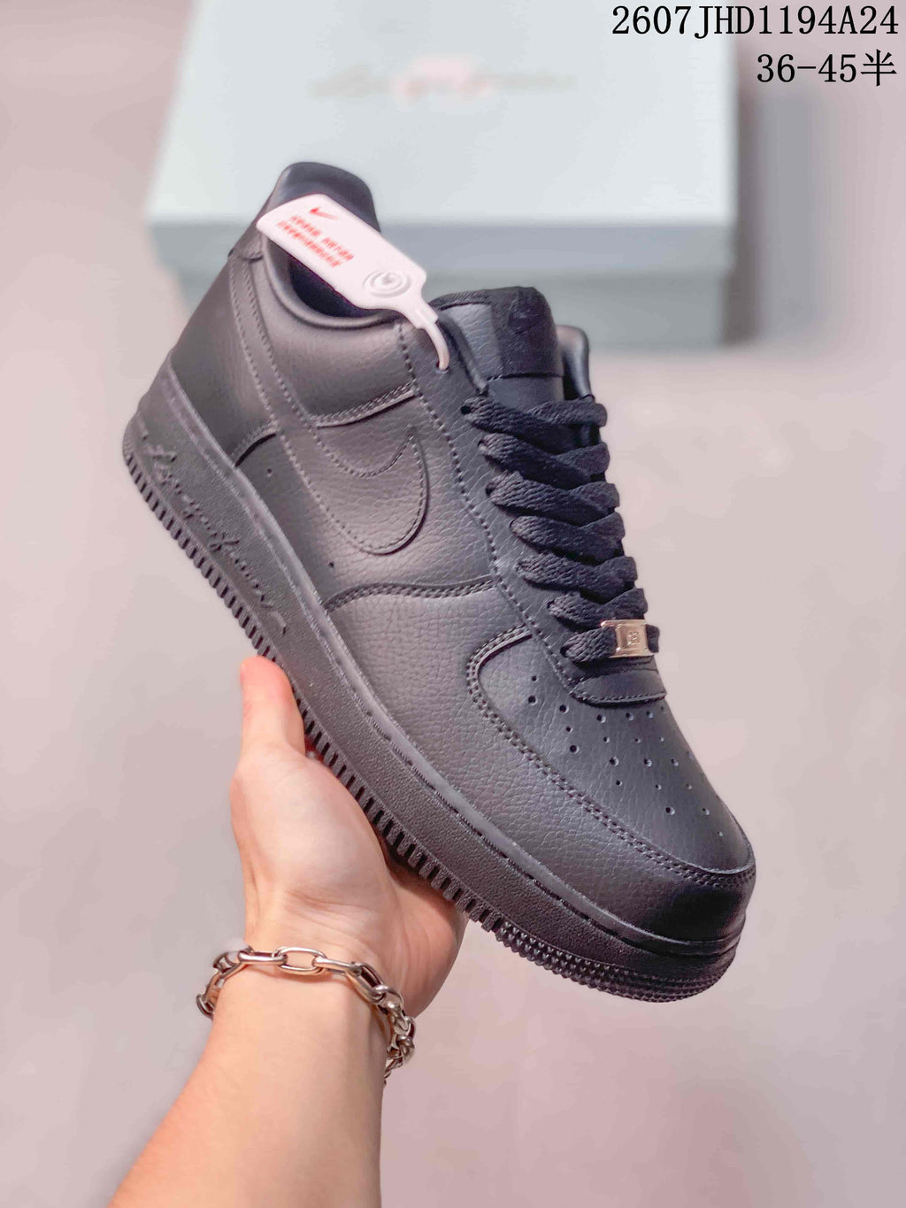 Angled view of a black Nike Air Force 1 '07 sneaker showing the tonal Swoosh, perforated toe panel and padded collar.