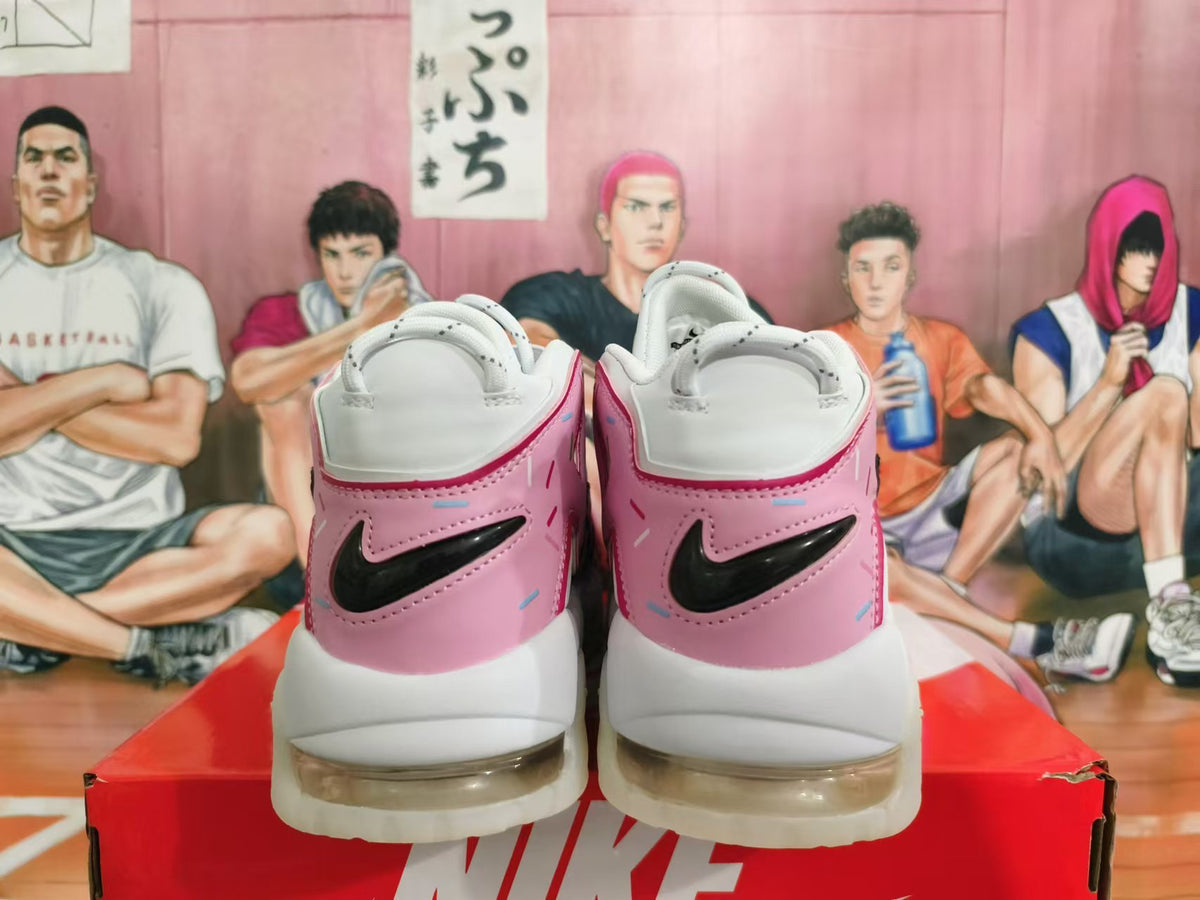Rear view of white and pink Nike sneakers with black Swoosh details and sprinkle-like accents.