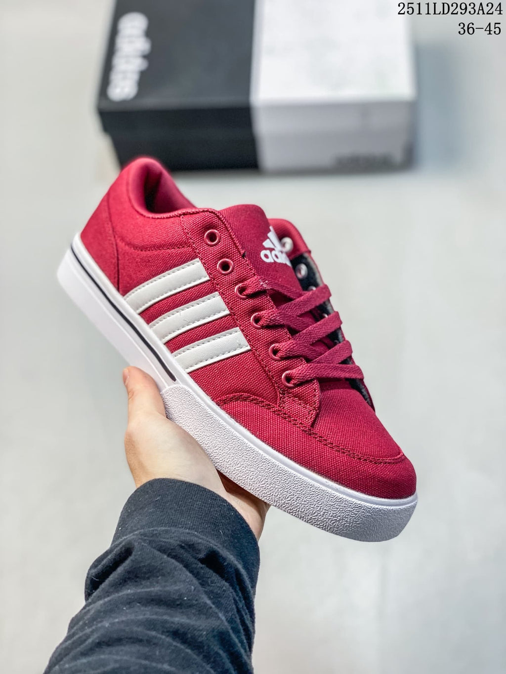 Angled side view of the red adidas sneaker with white stripes and a white rubber sole.