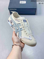 Angled front view highlighting the cream toe, pale blue side stripes, layered overlays, and low-top silhouette.