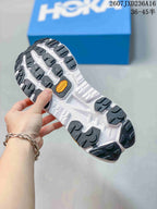 Underside view of the MAFATE X shoe showing a white outsole with black lugged traction sections and a central orange Vibram-branded insert.