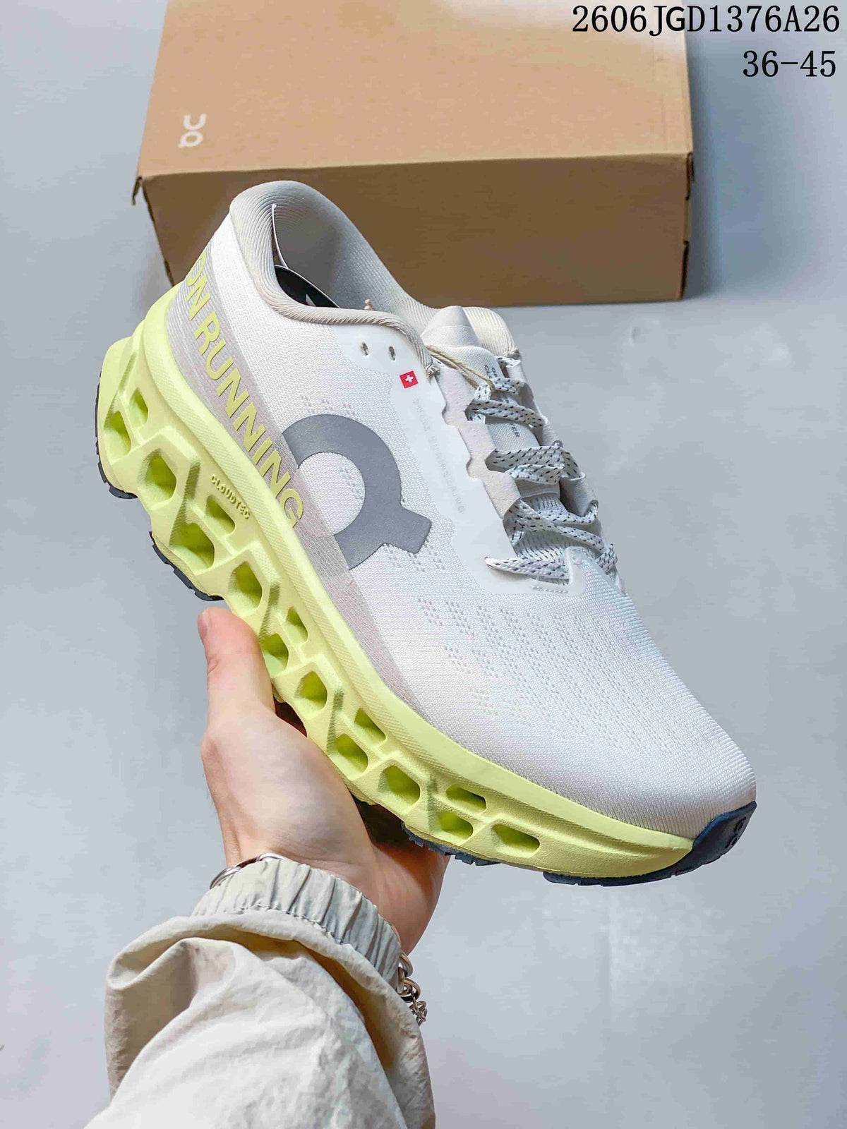 Angled side view of the white and lime On Cloudmonster 3 shoe showing the large side logo, lace closure and segmented midsole.