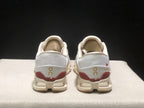 Rear view of the white On Cloud X4 pair showing gold heel branding and burgundy heel accents.