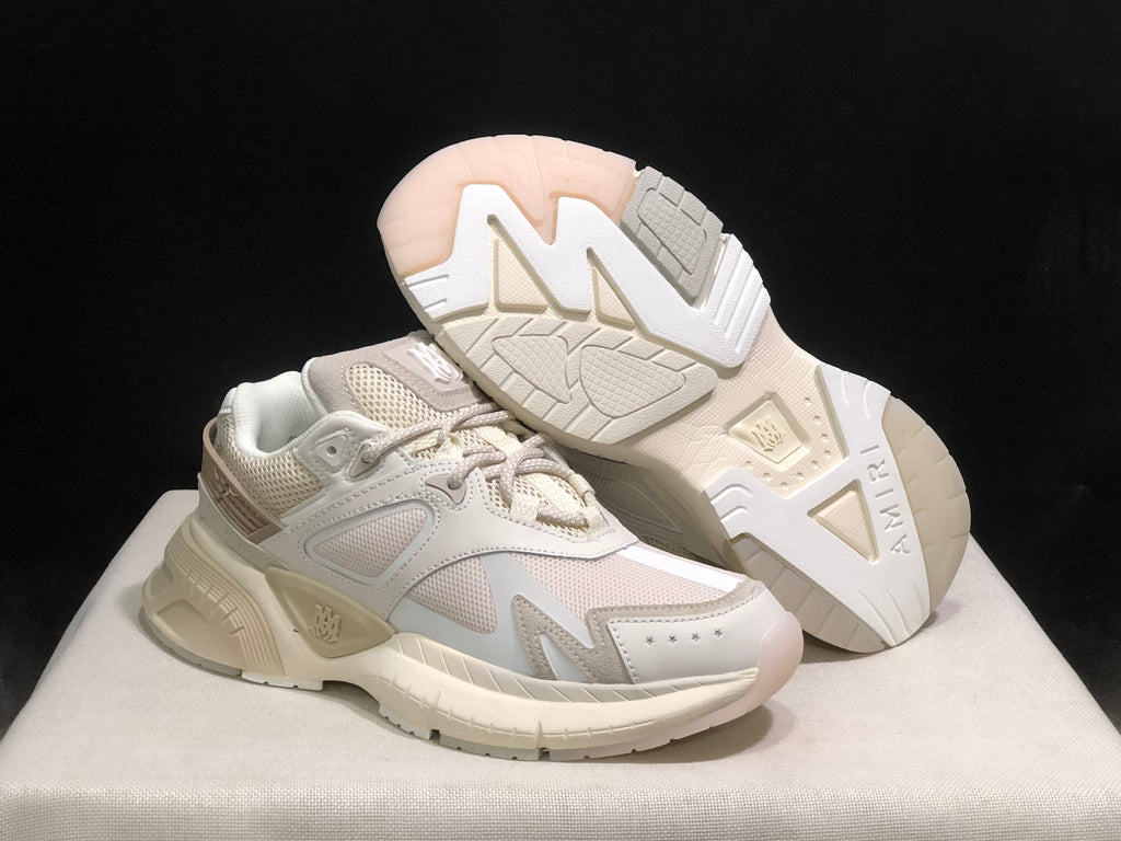 AMIRI MA Runner sneakers shown from an angled front view, including the patterned outsole of one shoe.