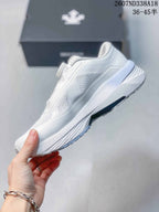 Side view of the white low-top sneaker showing the perforated panels, layered upper and thick cushioned sole.