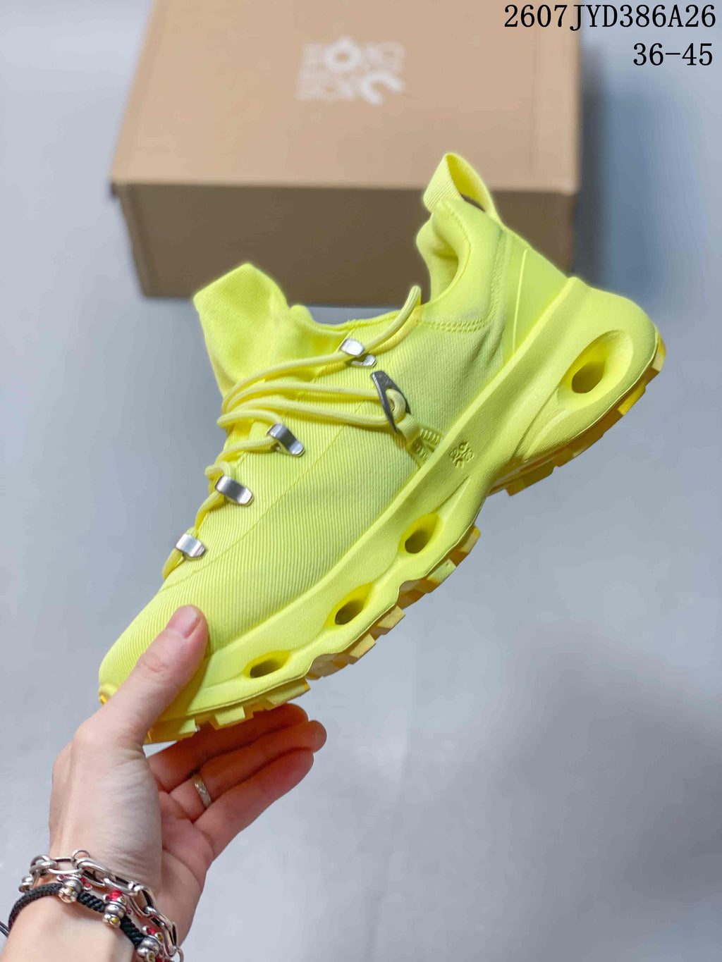 Side view of the neon yellow sneaker showing the textured upper, metal-tone lace hardware, open midsole channels, and lugged outsole.