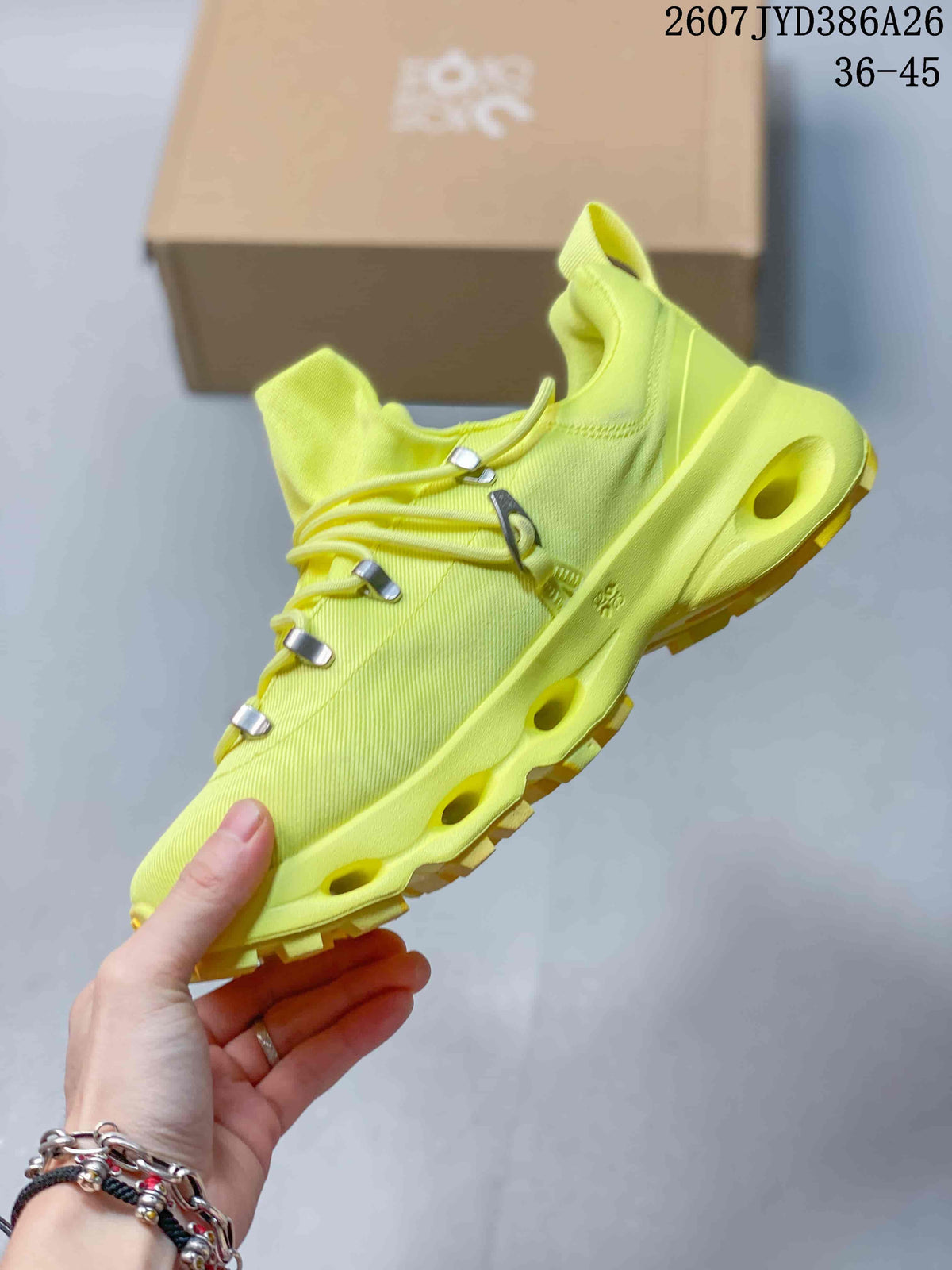 Side view of the neon yellow sneaker showing the textured upper, metal-tone lace hardware, open midsole channels, and lugged outsole.