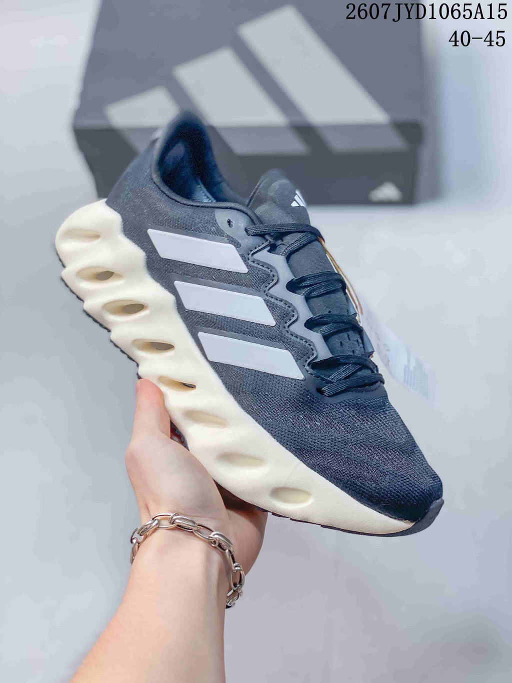 Angled side view of the Adidas Alphabounce Switch sneaker showing the dark upper, white side details and sculpted midsole.