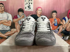 Front view of the pair showing white laces, patterned uppers, black tongue branding and grey outsoles.