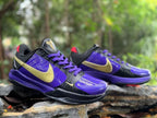 Pair of Nike Kobe 5 basketball shoes in purple, black and gold, shown at an angle.