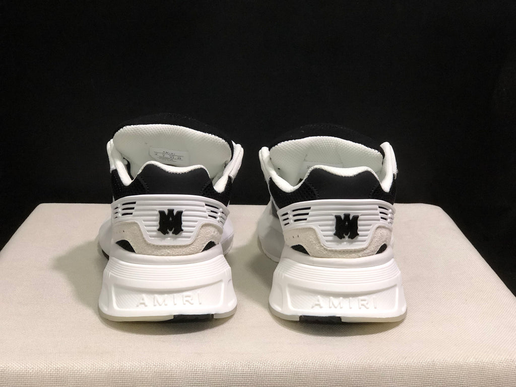 Rear view of the sneakers showing AMIRI branding, heel details and white midsoles.