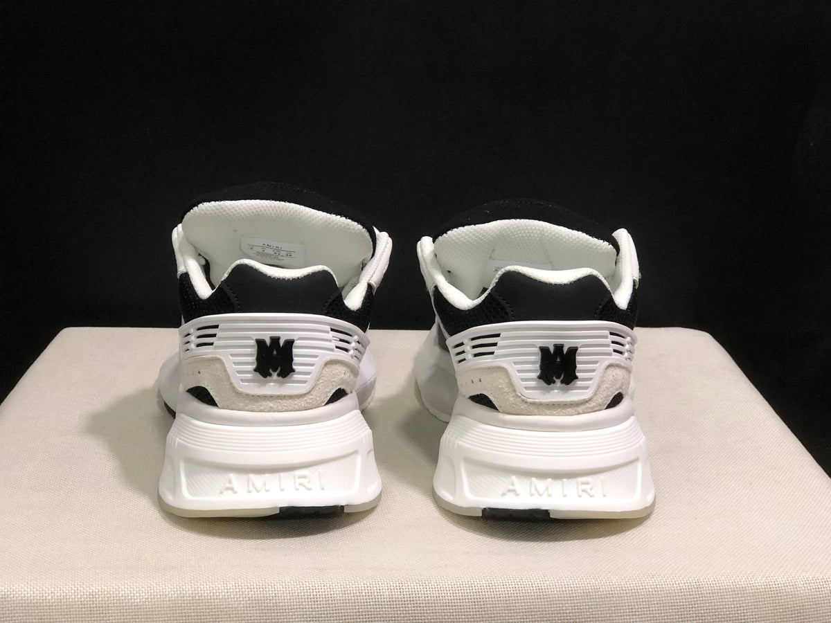 Rear view of the sneakers showing AMIRI branding, heel details and white midsoles.