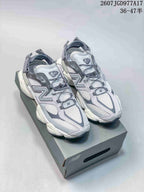 Pair of grey and white New Balance 9060 sneakers displayed on a shoe box.