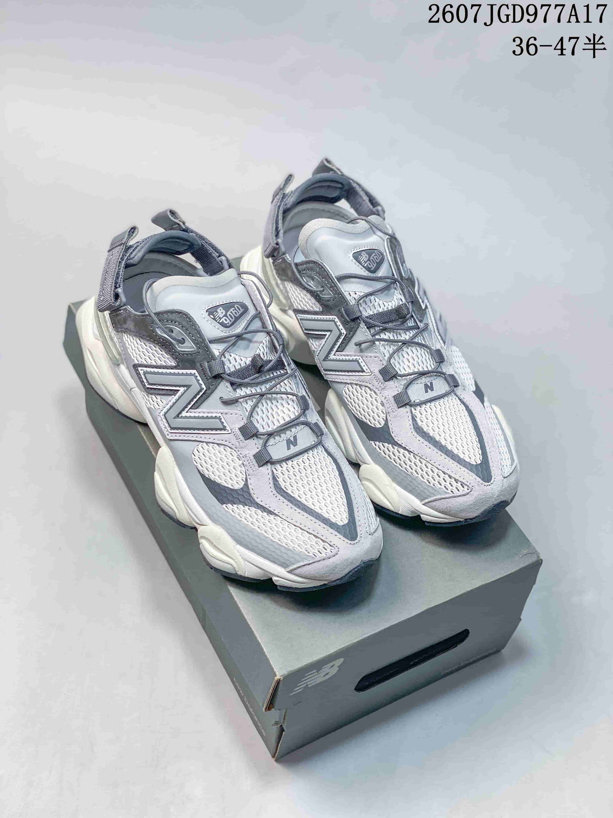 Pair of grey and white New Balance 9060 sneakers displayed on a shoe box.