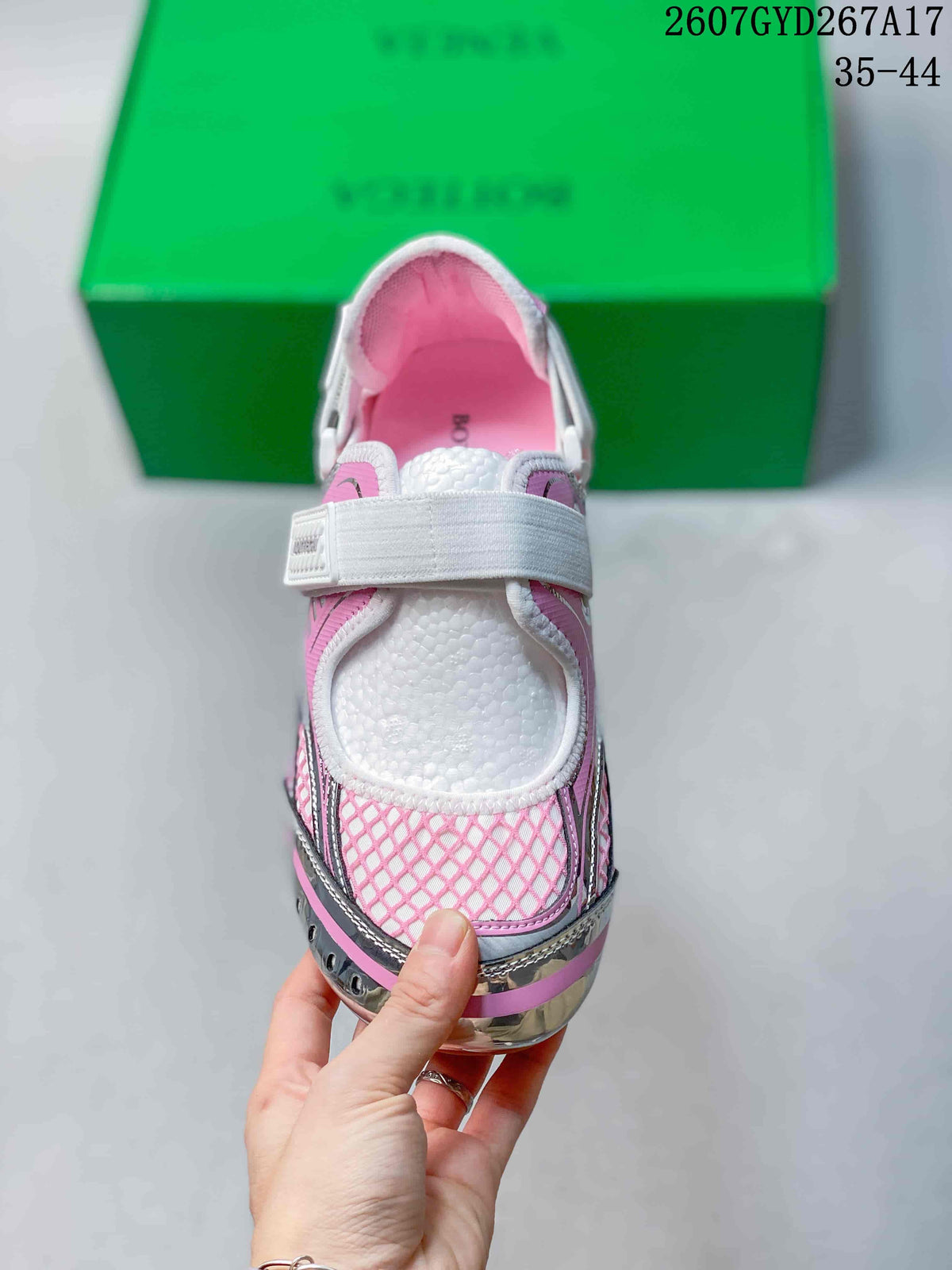 Top view showing the rounded toe, white strap, pink mesh-style detailing, and white tongue.