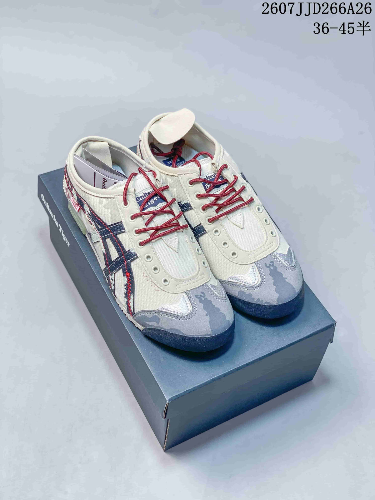 Pair of cream Onitsuka Tiger Mexico 66 Deluxe sneakers displayed on a branded shoebox, showing navy stripes, red laces, and gray patterned toe panels.