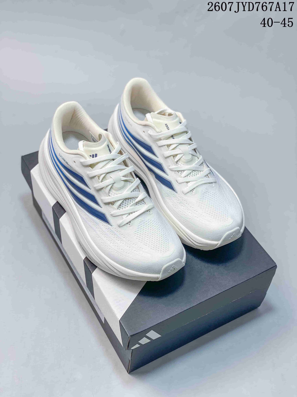 Pair of white Adidas sneakers with blue side accents and matching white laces.