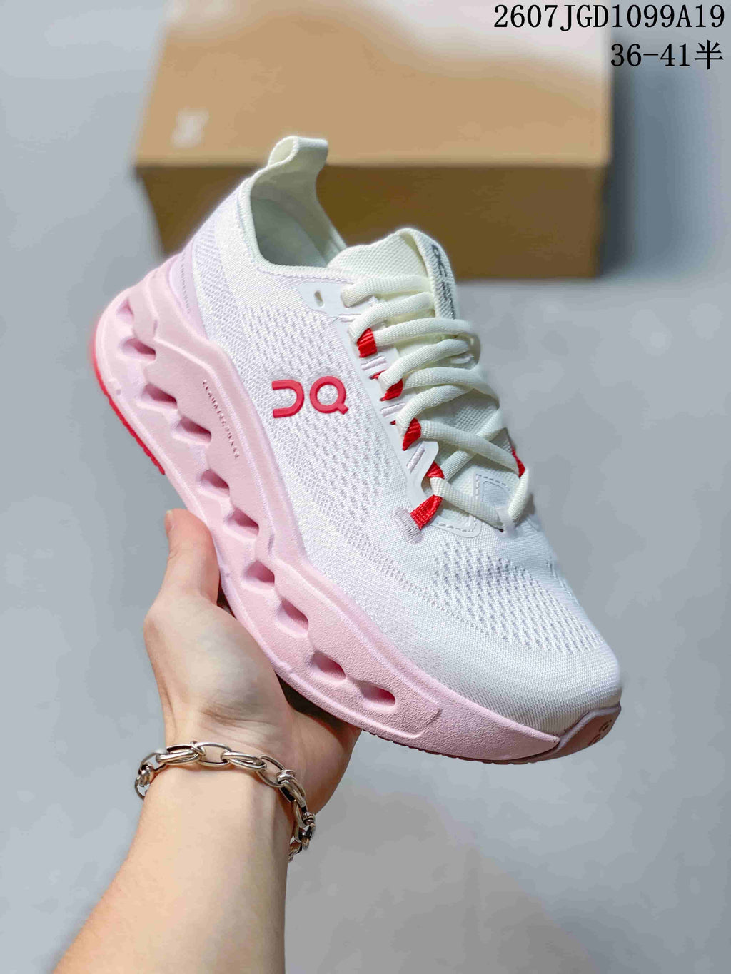 Angled side view of the white On Cloudtilt sneaker with red accents, pink outsole and sculpted sole openings.