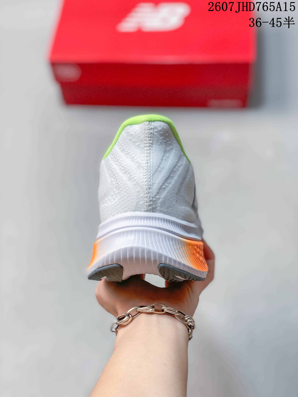 Rear view of the white running shoe showing the lime-green collar and orange heel accent.